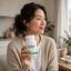 Persona adulta sosteniendo el envase del producto DetoxSi en un entorno hogareño tranquilo con luz natural.