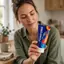 Mujer adulta sosteniendo un tubo de crema Femiform de 60 ml en un entorno doméstico tranquilo.