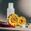 Naturaleza muerta editorial elegante con flores de árnica, un chile rojo y sutiles indicios botánicos de alcanfor y salicilato de metilo. Un tubo de gel de 75 ml desenfocado en el fondo.
